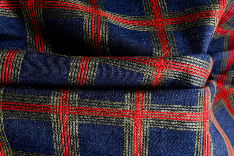 Fabric of different kinds for sewing clothes. Denim, costume, checkered,  blue red fabric for sewing clothes. Textile folded into a pile. Stock Photo